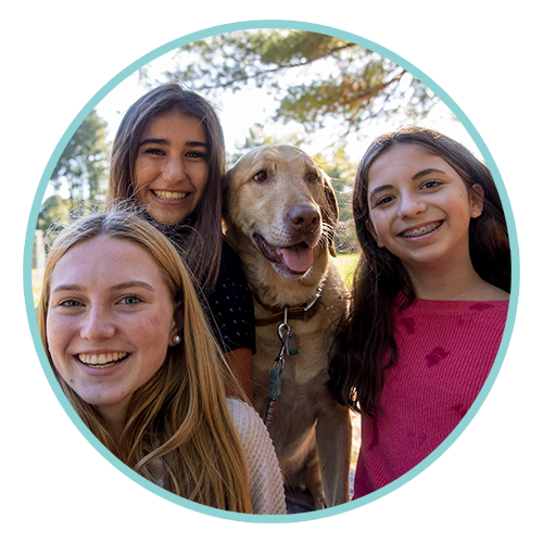 a group of girls taking a selfie with their dog